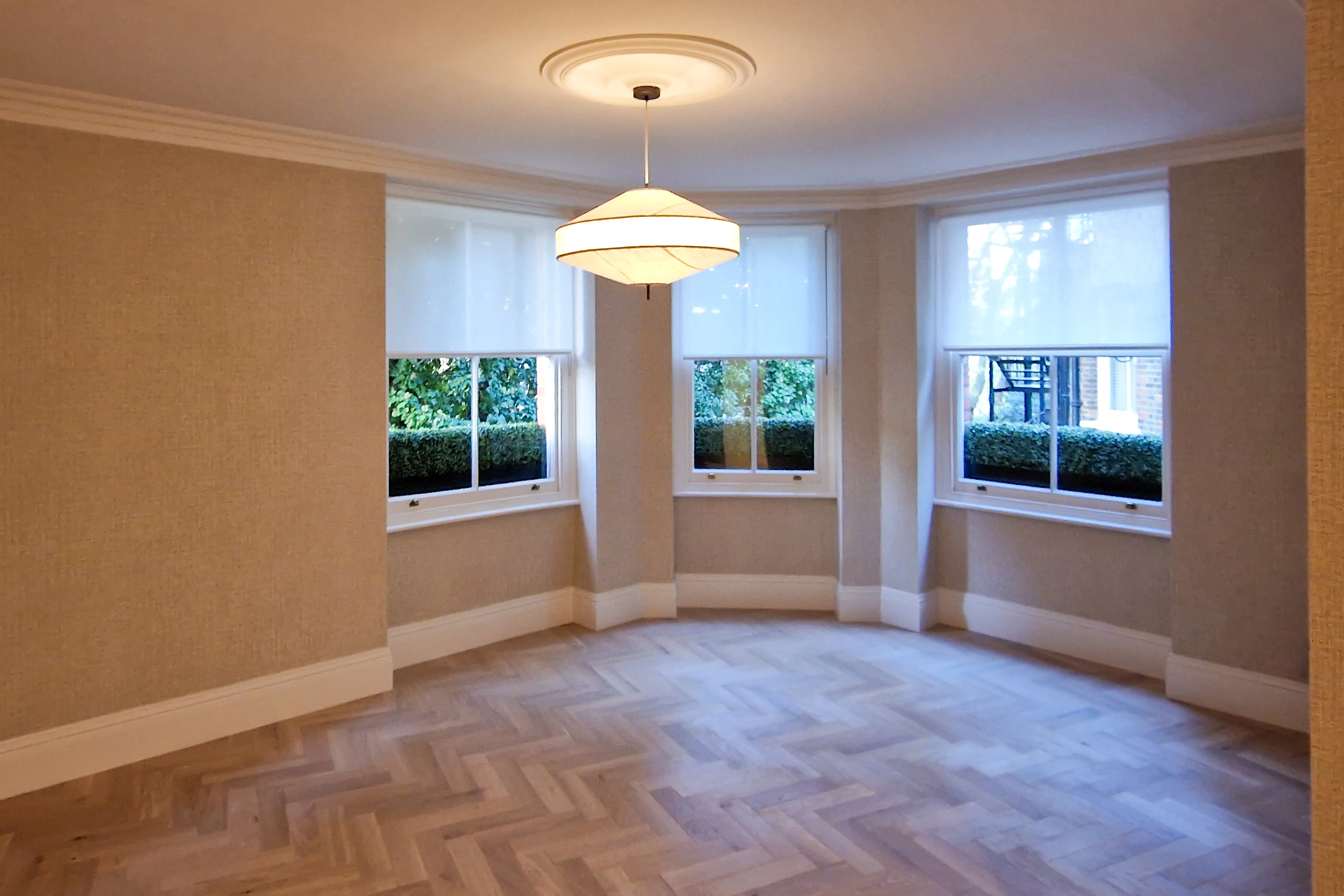 Living room in Epsom featuring bespoke joinery and herringbone wood flooring
