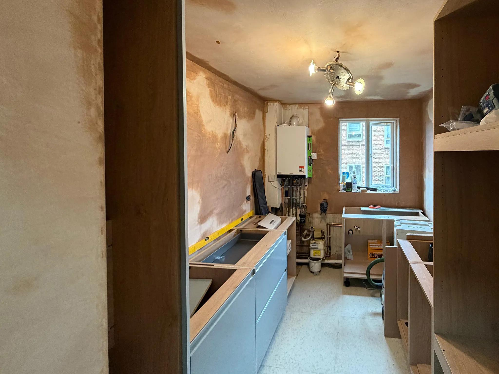 Kitchen fitter assembling fitted kitchen carcasses during installation process in Surrey