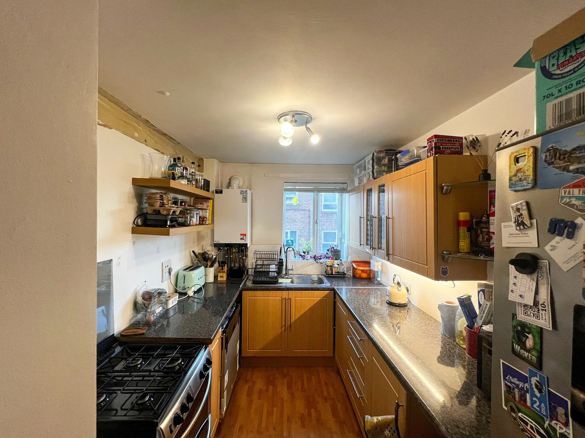 Narrow galley kitchen before renovation in Sutton Surrey – old wooden cabinets and dark worktops