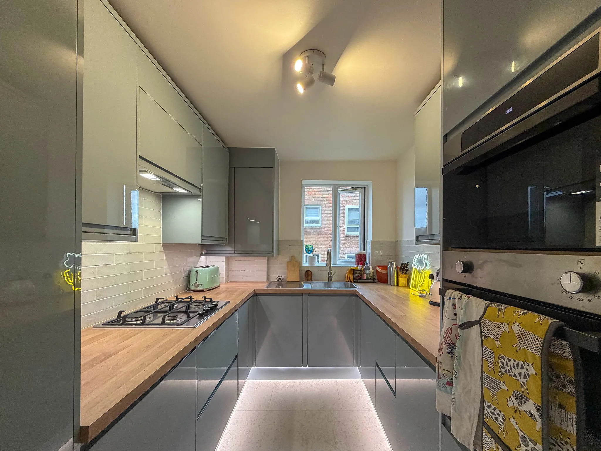 Bespoke narrow galley kitchen in Sutton — handleless units and LED lighting maximising space