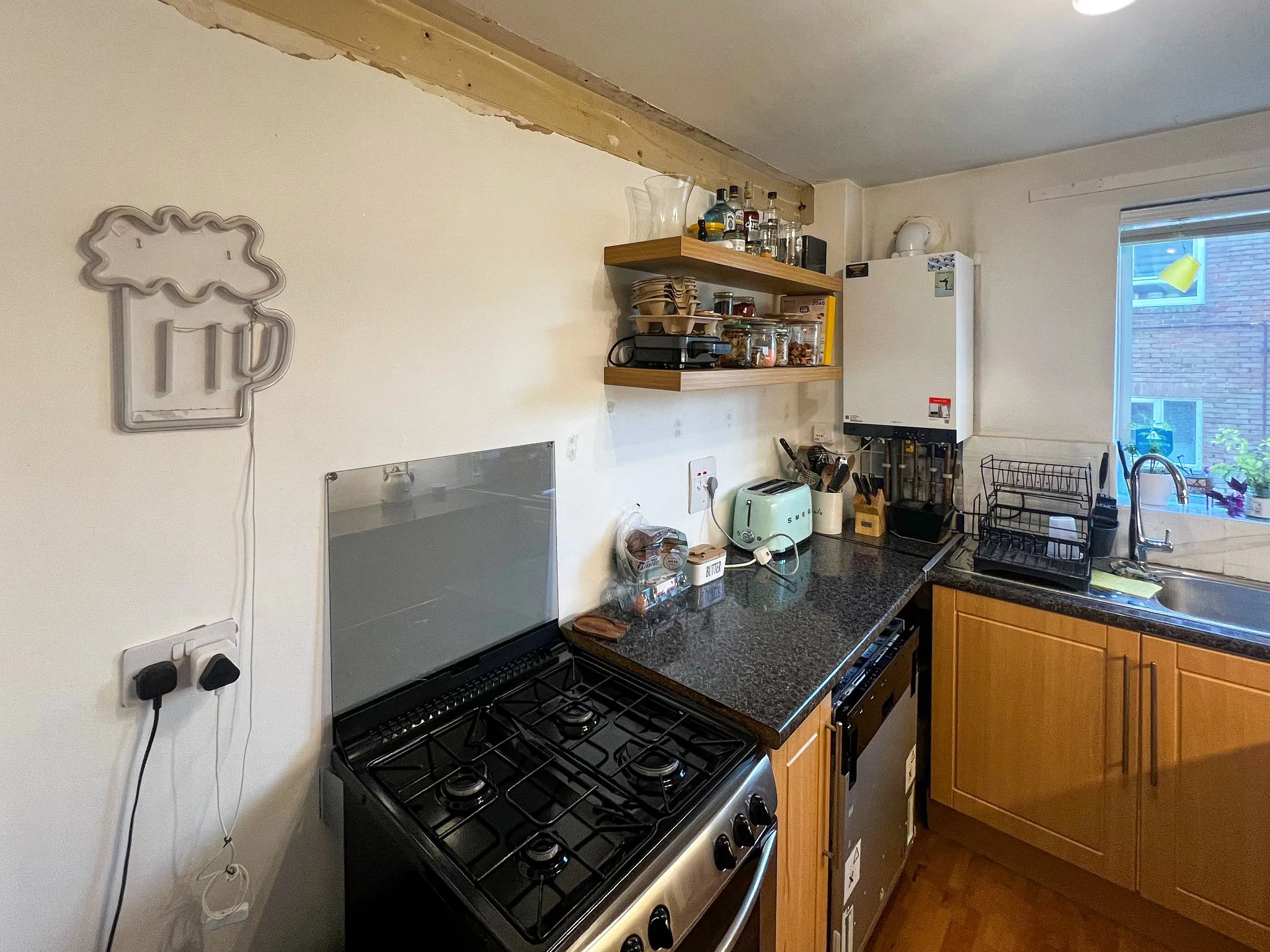 Old narrow kitchen cooking area before renovation in Sutton Surrey – dated wooden units and gas cooker
