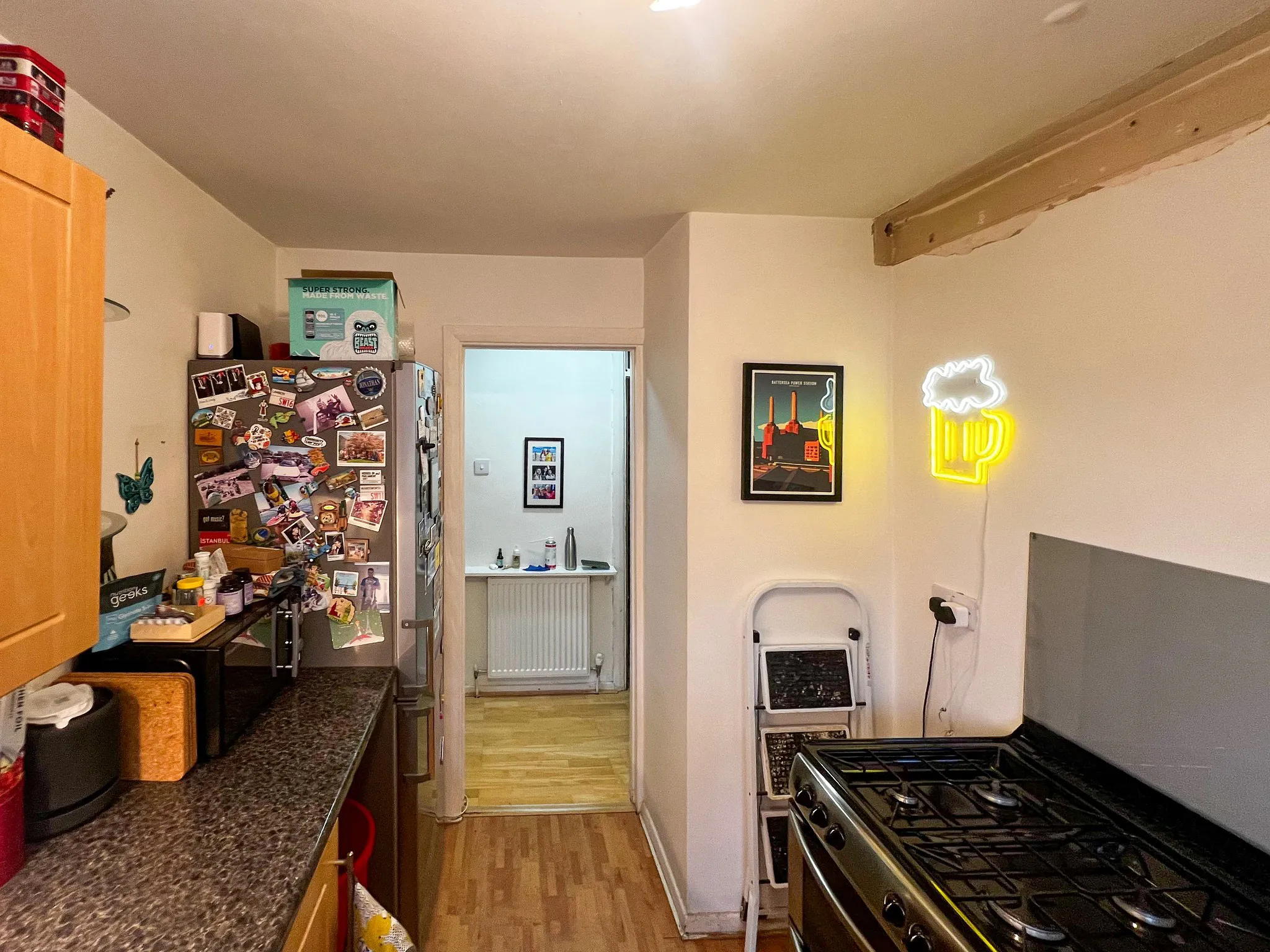 Narrow kitchen before refurbishment in Sutton — old wooden cabinets and cluttered layout