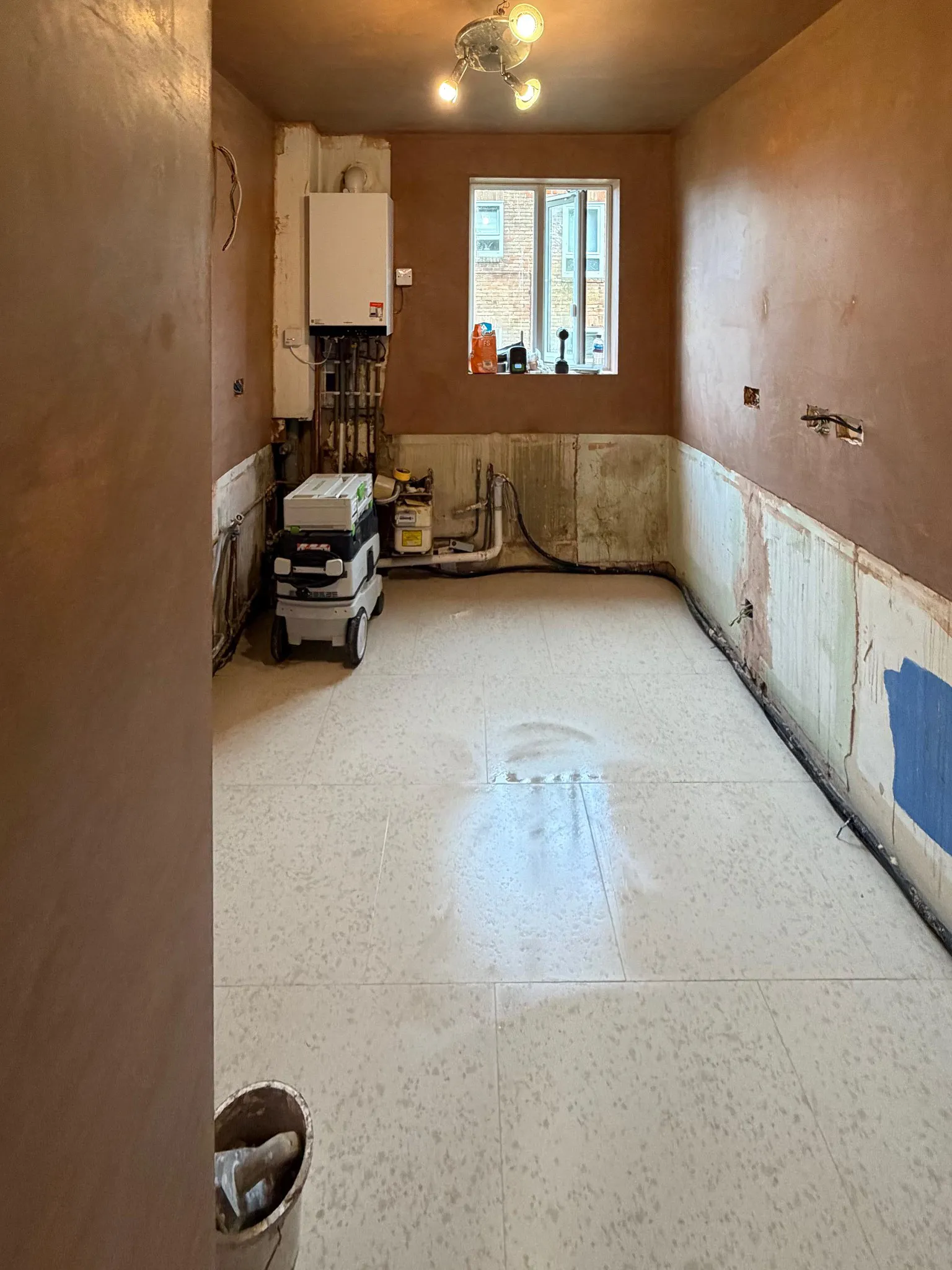 Wall plastering and floor tiling preparation during kitchen renovation in Sutton Surrey