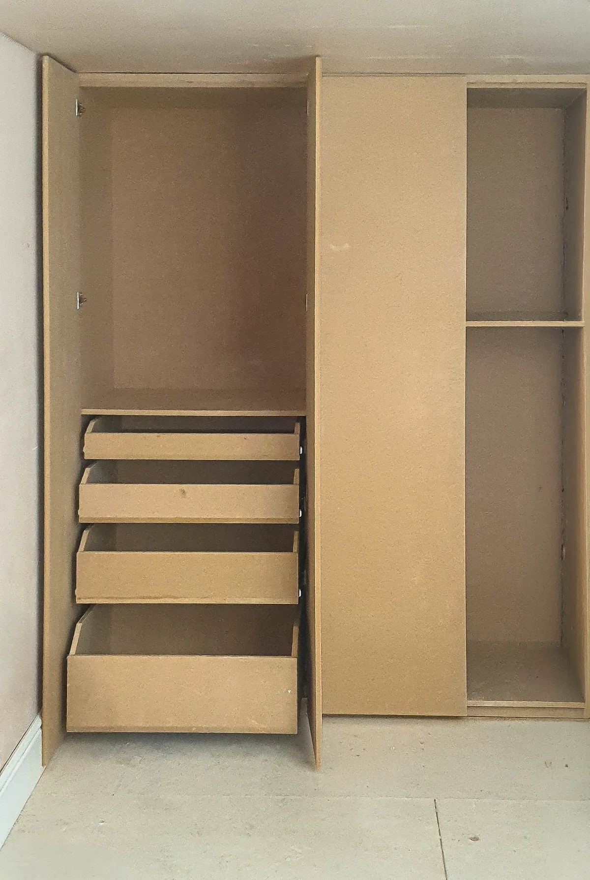Four pull-out drawers built into a fitted wardrobe in Beckenham, alongside full-height hanging space