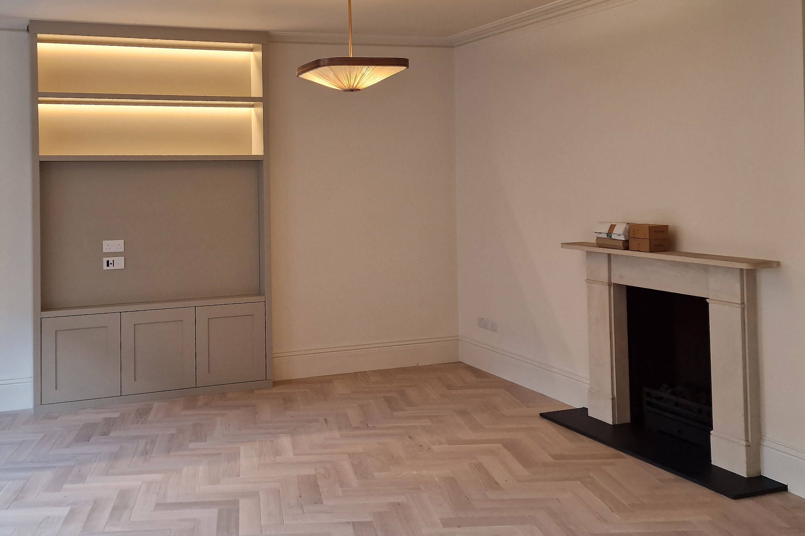 Bespoke living room storage unit with backlit shelving and herringbone parquet flooring, Chelsea SW10