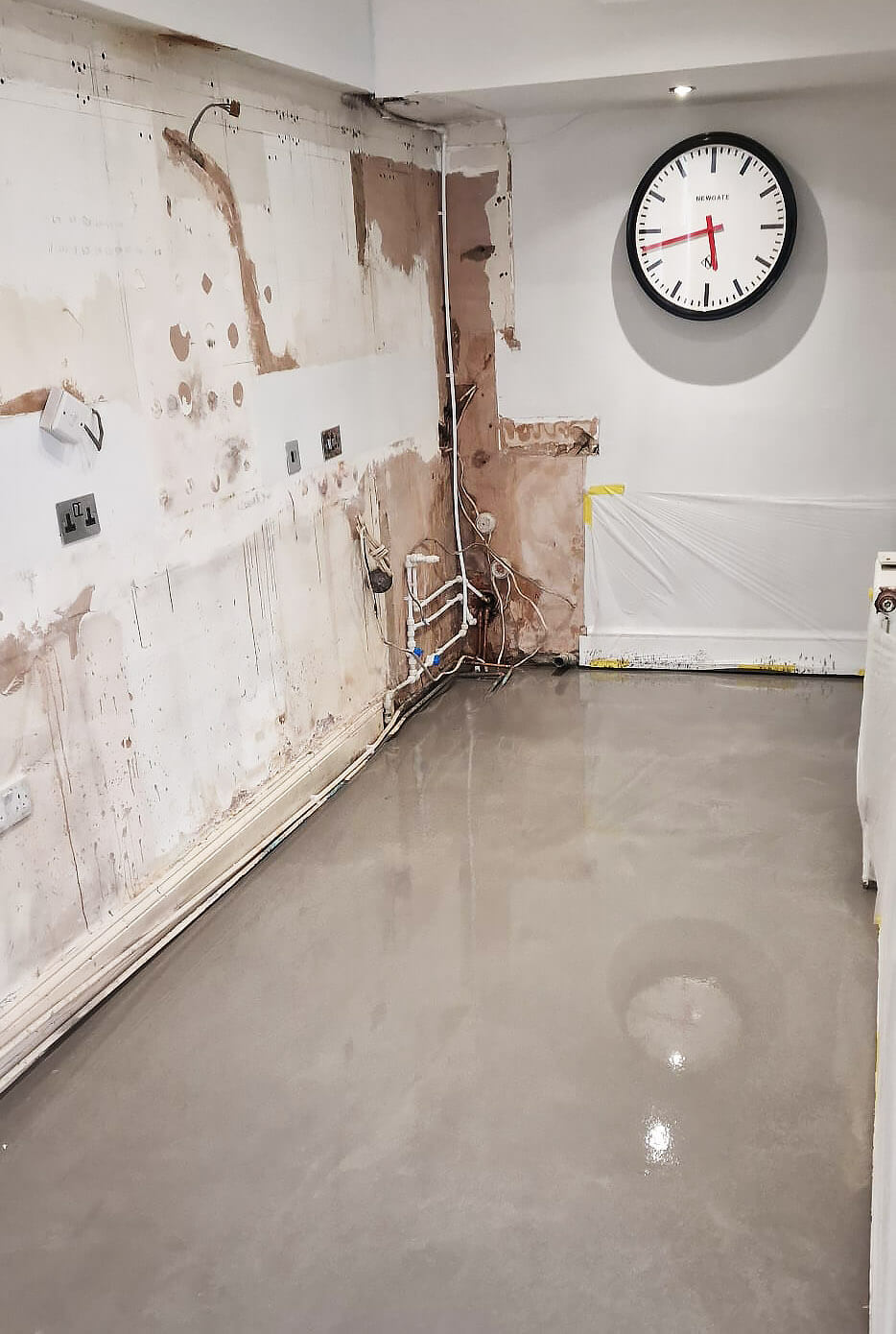 Self-levelling screed poured over an uneven kitchen floor in Shepherds Bush