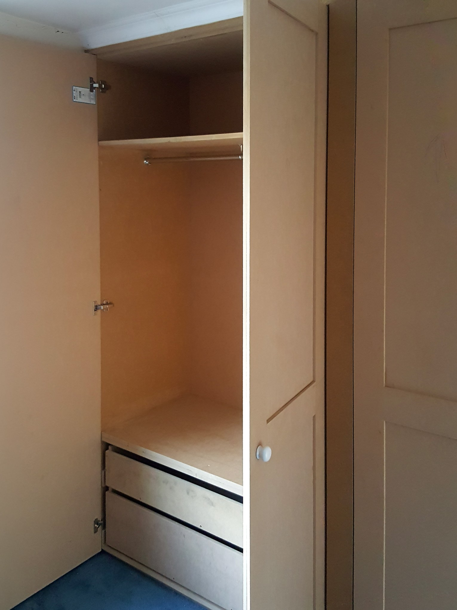 Built-in wardrobe: hanging rail and drawers Built-in wardrobe with open door showing a hanging rail, top shelf and two drawers