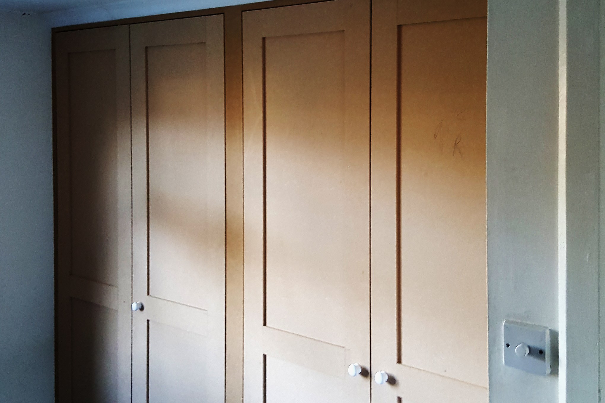 Built-in wardrobe: closed Shaker doors Closed Shaker-style doors with white knobs on a built-in wardrobe in Streatham Hill