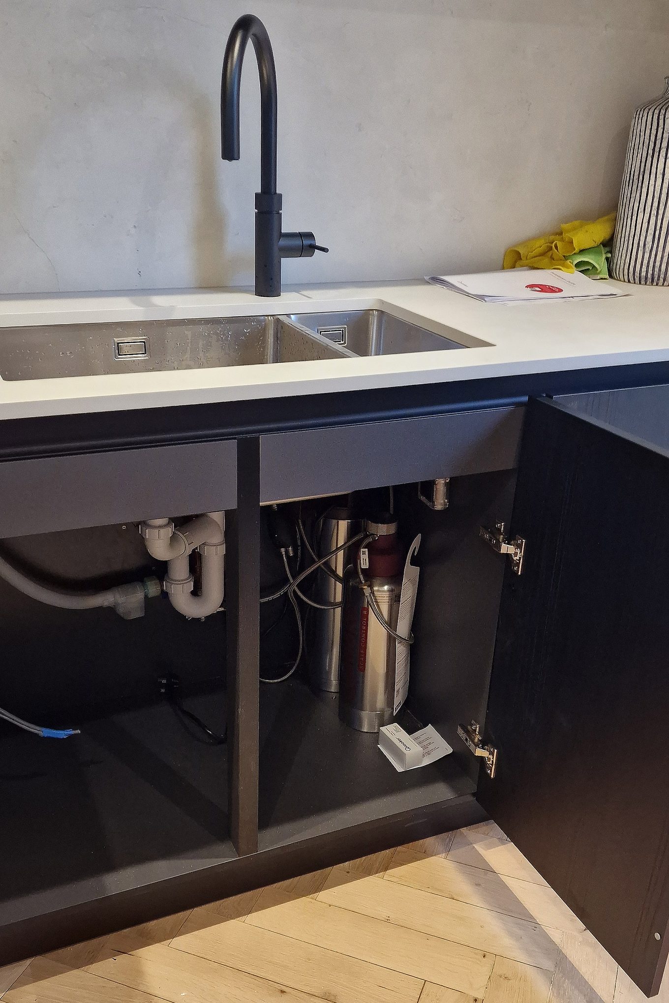 Double-bowl sink with a black mixer tap and the plumbing connected inside the open base unit, kitchen in Hampton Wick