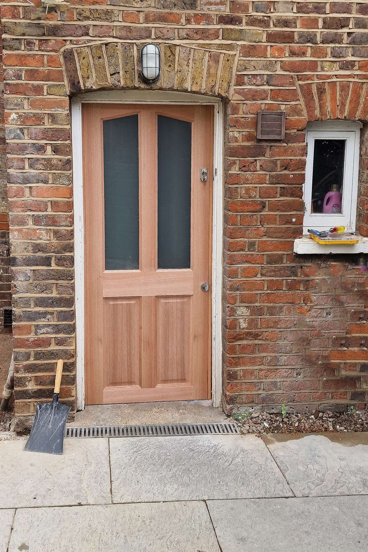New timber external door with frosted glass panels under a brick arch in Hampton Wick