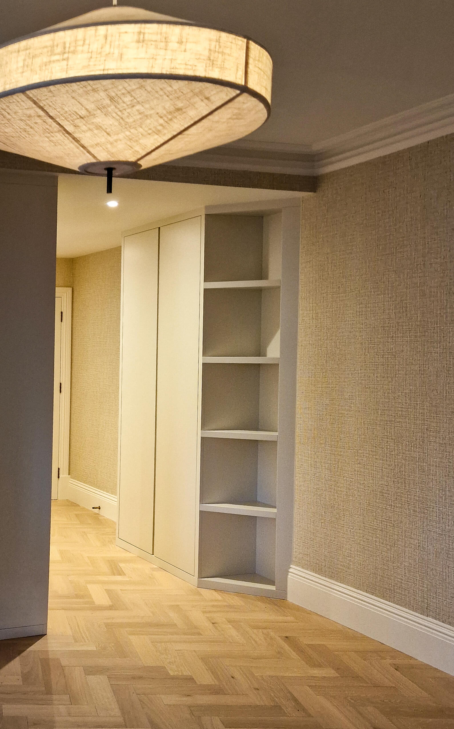 Fitted wardrobe and shelving, Chelsea SW10 property Bespoke fitted wardrobe and open shelving unit in a Chelsea hallway, painted joinery with herringbone flooring