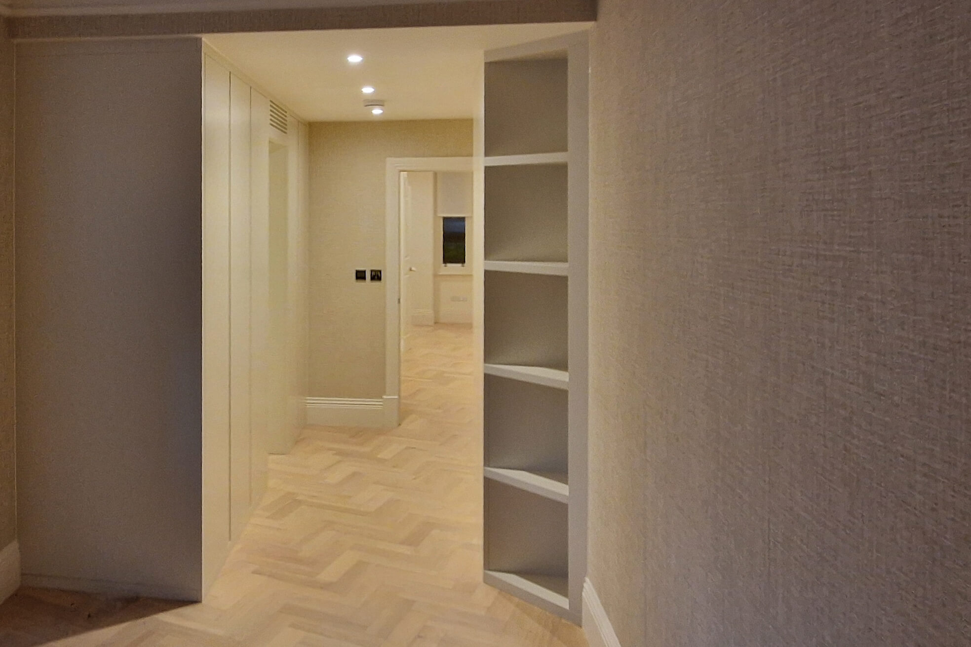 Wide view of fitted hallway cabinetry and open shelving built into a corner recess, Chelsea SW10