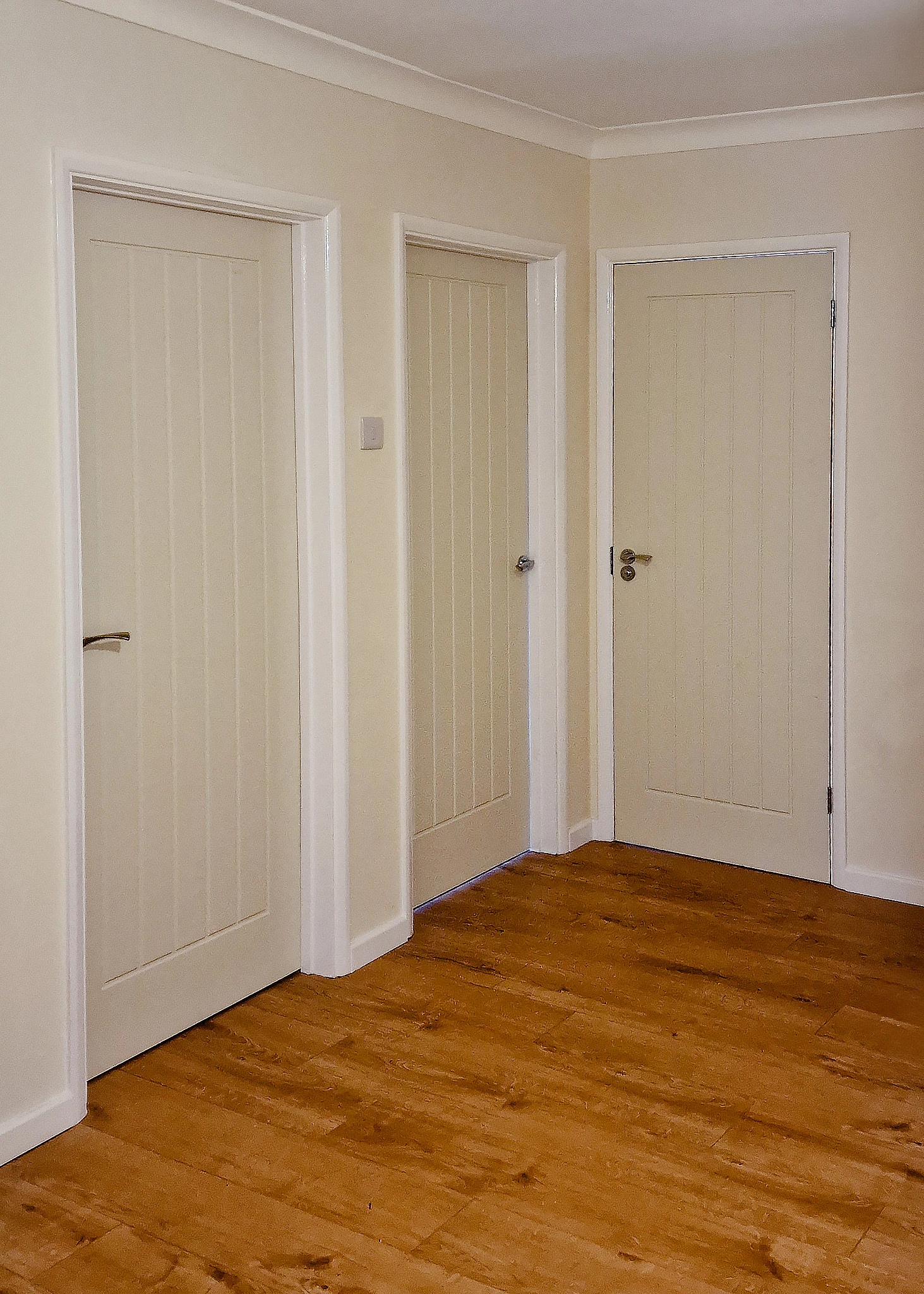 Howdens Dordogne White Moulded Doors fitted in a Surrey hallway — internal door replacement Three Howdens Dordogne White Smooth Moulded internal doors installed in a hallway corner in Boxhill, Surrey, fitted to existing frames